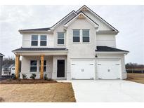Charming two-story home featuring a two-car garage, white brick, and striking black roof at 358 Orwell Dr, Social Circle, GA 30025
