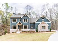 Beautiful two-story home featuring a charming exterior, landscaped yard, and elegant architectural details at 7636 Chestnut Hill Rd, Cumming, GA 30041