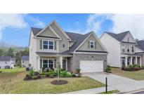 Charming two-story home boasts a brick and siding facade, well-manicured lawn, and inviting curb appeal at 4650 Sandy Creek Dr, Cumming, GA 30028