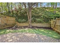 Private backyard retreat featuring a charming stone waterfall and well-maintained artificial turf at 1209 Brookhaven Woods Ne Ct, Brookhaven, GA 30319