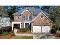 Charming two-story brick home with a well-manicured lawn, two-car garage, and inviting front entry at 12554 Huntington Trce, Alpharetta, GA 30005