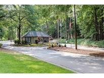 Gated community entrance features beautiful landscaping and a guard house for added security at 102 Adrian Nw Pl, Atlanta, GA 30327