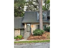 Charming townhome featuring a brick facade, well-maintained landscaping, and inviting entrance, at 102 at 102 Adrian Nw Pl, Atlanta, GA 30327