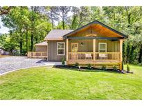 Charming home with a covered front porch, stylish lighting, and lush green lawn at 3244 Mount Olive Rd, Atlanta, GA 30344