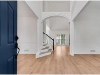 Inviting foyer featuring soaring ceilings, staircase, wood floors, and an abundance of natural light at 4414 Aldenham Way, Suwanee, GA 30024