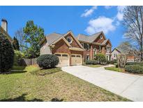 Charming brick home featuring an attached two-car garage, beautiful landscaping, and a spacious driveway at 5222 Camden Lake Nw Pkwy, Acworth, GA 30101
