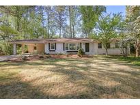 Charming single-story home with white brick, a covered carport, and a well-manicured front yard at 1384 Windburn Dr, Marietta, GA 30066