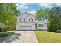 Charming two-story home boasts a well-manicured lawn, attached two-car garage, and beautiful curb appeal at 1900 Foster Trace Ct, Lawrenceville, GA 30043