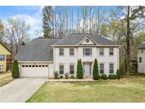 Charming two-story home featuring a manicured front lawn and attached two-car garage at 300 Radner Run, Lawrenceville, GA 30043