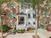 Charming townhome with manicured front garden, brick and white painted exterior at 3932 Boston Common St, Suwanee, GA 30024