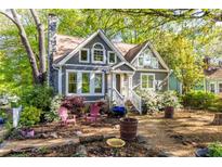 Charming two-story home with a landscaped front yard featuring a stone chimney and flowering bushes at 1326 Metropolitan Se Ave, Atlanta, GA 30316