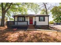 Charming single-story home features a red door, black shutters, and a cozy front porch at 2077 Perkerson Rd, Atlanta, GA 30310