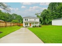 Charming two-story home features a well-manicured lawn, covered porch, and a cozy seating area at 90 Cerro St, Atlanta, GA 30314