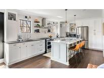This kitchen features a large island, stainless steel appliances, white cabinetry and pendant lighting at 4568 Oswood Ct, Tucker, GA 30084