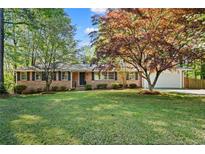 Charming brick home featuring mature landscaping and a well-manicured lawn at 1618 Cooper Lake Se Rd, Smyrna, GA 30082