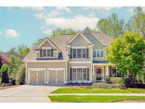 Charming two-story home with a well-manicured lawn, attached two car garage, and mature trees at 4106 Creekview Ridge Ne Dr, Buford, GA 30518