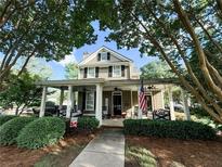Charming two-story home features a welcoming front porch with stylish seating and an American flag at 498 Trip St, Grayson, GA 30017