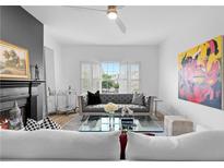 Inviting living room with a cozy fireplace, grey sofa, and bright natural light from the window at 108 Vinings Forest Se Cir, Smyrna, GA 30080