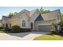 Charming stucco home with a two-car garage, complemented by lush landscaping and a well-maintained lawn at 4310 Wellbrook Ct, Douglasville, GA 30135
