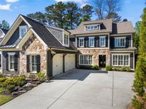 Beautiful two-story home featuring a stone and shingle exterior with a spacious driveway and a two-car garage at 201 Belle Ln, Sandy Springs, GA 30328