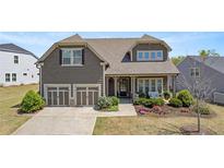 Charming two-story home with a well-manicured lawn, two-car garage, and inviting front porch at 347 Woodridge Pass, Canton, GA 30114