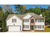 Charming two-story home with a two-car garage, stone accents and inviting curb appeal nestled amongst mature trees at 3554 Cherry Bloom Way, Decatur, GA 30034