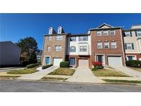 Attractive brick and siding townhomes with well-manicured lawns and individual driveways at 528 Lantern Wood Dr, Scottdale, GA 30079