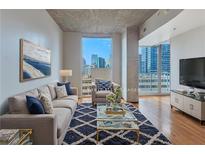 Bright living room with large windows offering stunning city views and stylish decor at 860 Peachtree Ne St # 1010, Atlanta, GA 30308