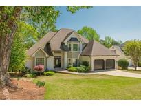 Charming two-story home with well-manicured lawn, a two-car garage, and mature trees enhancing its curb appeal at 10575 Wren Ridge Rd, Alpharetta, GA 30022