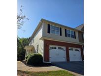 Two-story townhome featuring a brick facade, two-car garage and classic black window shutters at 1960 Dakota Nw Dr, Acworth, GA 30101