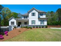 Stunning two-story home with modern farmhouse charm and well-manicured lawn at 5138 Price Dr, Suwanee, GA 30024