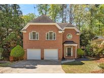 Charming two-story brick home featuring a two-car garage and well-manicured landscaping at 1020 Burton Ne Dr, Atlanta, GA 30329