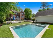 This backyard features a gorgeous pool and spa, fire pit area, and play equipment to complete this amazing outdoor space at 1116 Dan Johnson Ne Rd, Atlanta, GA 30307