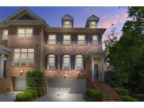 Charming brick townhome with manicured landscaping and attached garage, perfect for modern living at 1561 Mosaic Way, Smyrna, GA 30080