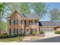 Charming two-story brick home with black shutters and a well-manicured front yard at 1826 Bedfordshire Ct, Decatur, GA 30033