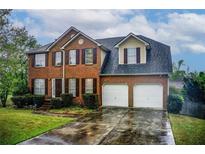 Charming two-story brick home with a two-car garage and well-manicured lawn at 2121 Silva Ct, Conley, GA 30288