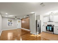 Open-concept living room features hardwood floors and a stylish accent wall and updated kitchen at 3460 Fairlane Dr, Atlanta, GA 30331