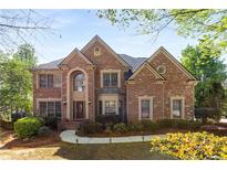 Charming two-story brick home with manicured landscaping and mature trees on a sunny day at 482 Cooper Lake Se Rd, Smyrna, GA 30126