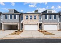 New townhome with brick and siding, featuring attached garages and professional landscaping at 1016 Rose Dr, Marietta, GA 30060