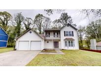 Two-story home with a two-car garage, balcony, and manicured front lawn at 2740 Ashley Downs Ln, Atlanta, GA 30349