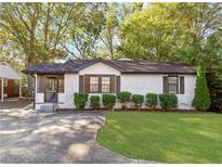 Charming white brick home with a well-manicured lawn and lovely landscaping at 1340 Hawthorne Se Ave, Smyrna, GA 30080