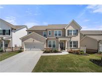 Charming two-story home featuring a two-car garage, manicured lawn, and inviting front porch at 2770 Westgate Park Dr, Loganville, GA 30052