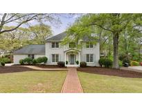 Charming two-story brick home with mature landscaping and a welcoming brick walkway at 640 Saddle Ridge Trce, Roswell, GA 30076
