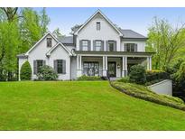Elegant white brick home with symmetrical design, dark shutters, and manicured lawn at 369 Pinecrest Ne Rd, Atlanta, GA 30342