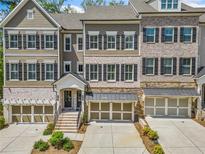 Beautiful townhome with a two-car garage, complemented by a meticulously landscaped front yard at 815 Paden St, Woodstock, GA 30188