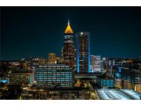 Nighttime cityscape view featuring illuminated skyscrapers against a dark sky, showcasing urban living at 860 Peachtree Ne St # 2716, Atlanta, GA 30308