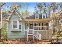 Charming cottage-style home with inviting front porch and landscaped yard at 495 Stratford Dr, Douglasville, GA 30134