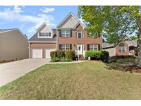 Charming two-story brick home with a well-manicured lawn, attached two-car garage, and inviting front entrance at 3978 Oak Crossing Drive Dr, Suwanee, GA 30024