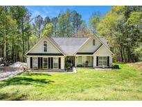 Charming single-Gathering home featuring a well-manicured lawn and inviting curb appeal with mature landscaping at 285 Willow Shoals Dr, Covington, GA 30016