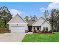 Charming single-story home with a two-car garage, well-manicured lawn, and fresh landscaping at 1195 Awenasa Dr, Villa Rica, GA 30180